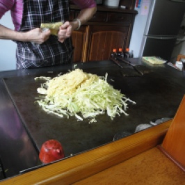 She started with cabbage and then added noodles on the giant hotplate